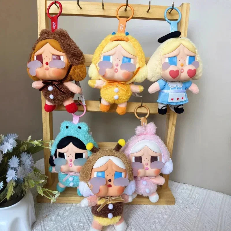 Set of colorful plush keychains on a wooden stand with a neutral background