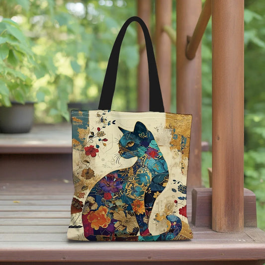 Tote bag with a colorful cat design on a wooden surface with a green outdoor background