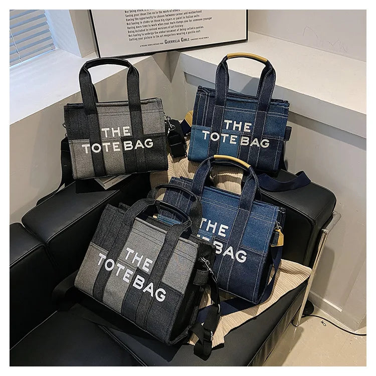 Multiple tote bags labeled 'THE TOTE BAG' on a black surface.