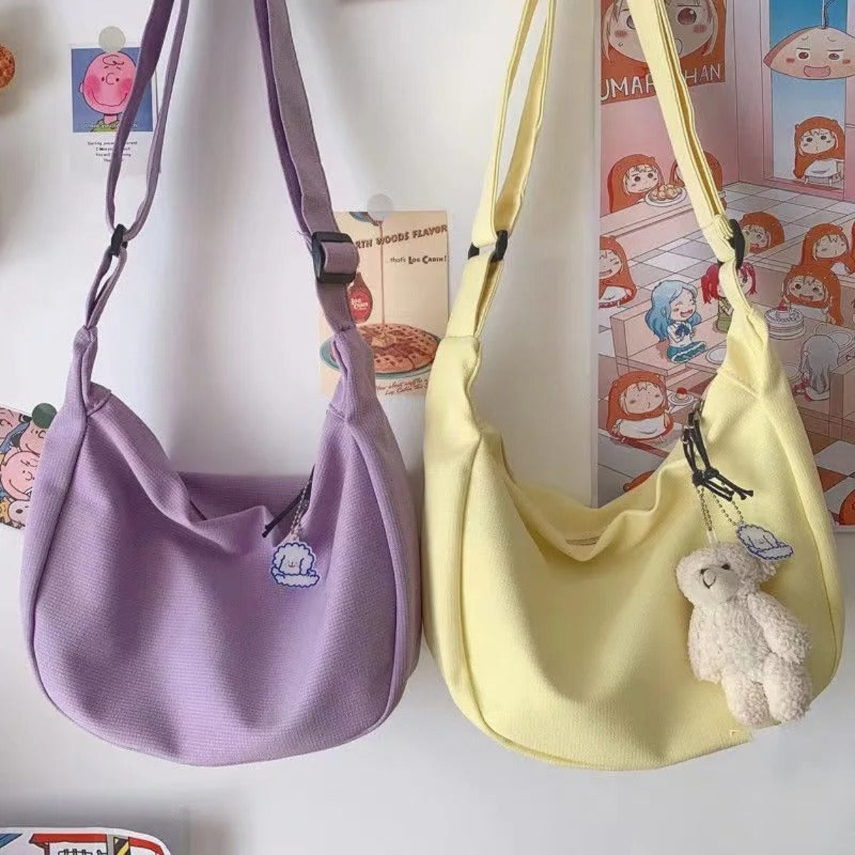 Two handbags, one purple and one yellow, with a small plush toy attached to the yellow bag.