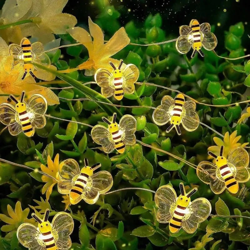 String lights shaped like bees on a green plant background