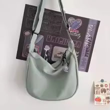 Light green handbag with a strap on a white background